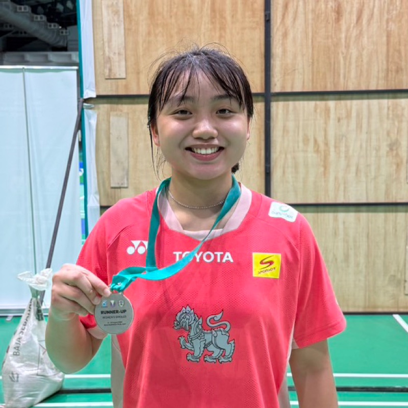Nu Waen, a Banthongyord player, smiling and holding her medal at the competition venue